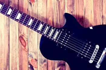 electric-guitar-on-a-wooden-table_1204-146